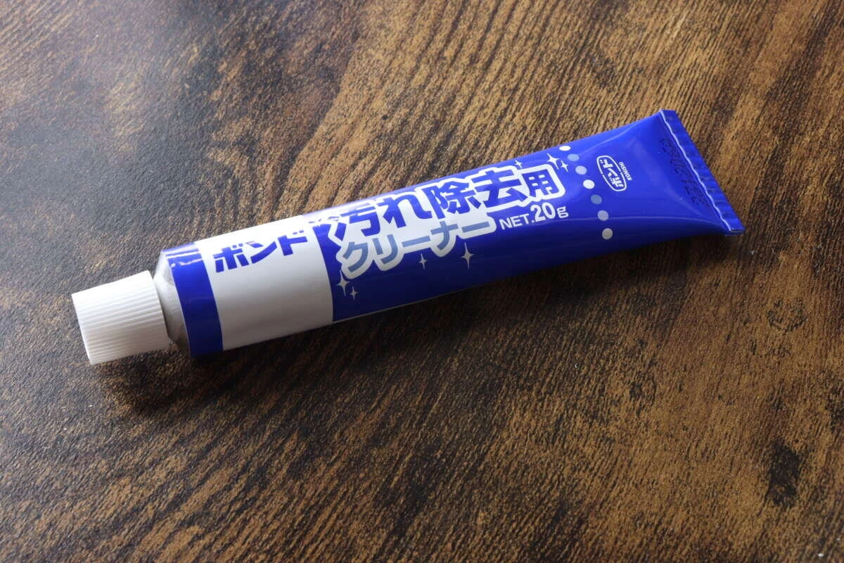 木目調のテーブルに置かれた、青と白の「ボンド 汚れ除去用クリーナー」のチューブ本体 木目調のテーブルに置かれた、青と白の「ボンド 汚れ除去用クリーナー」のチューブ本体