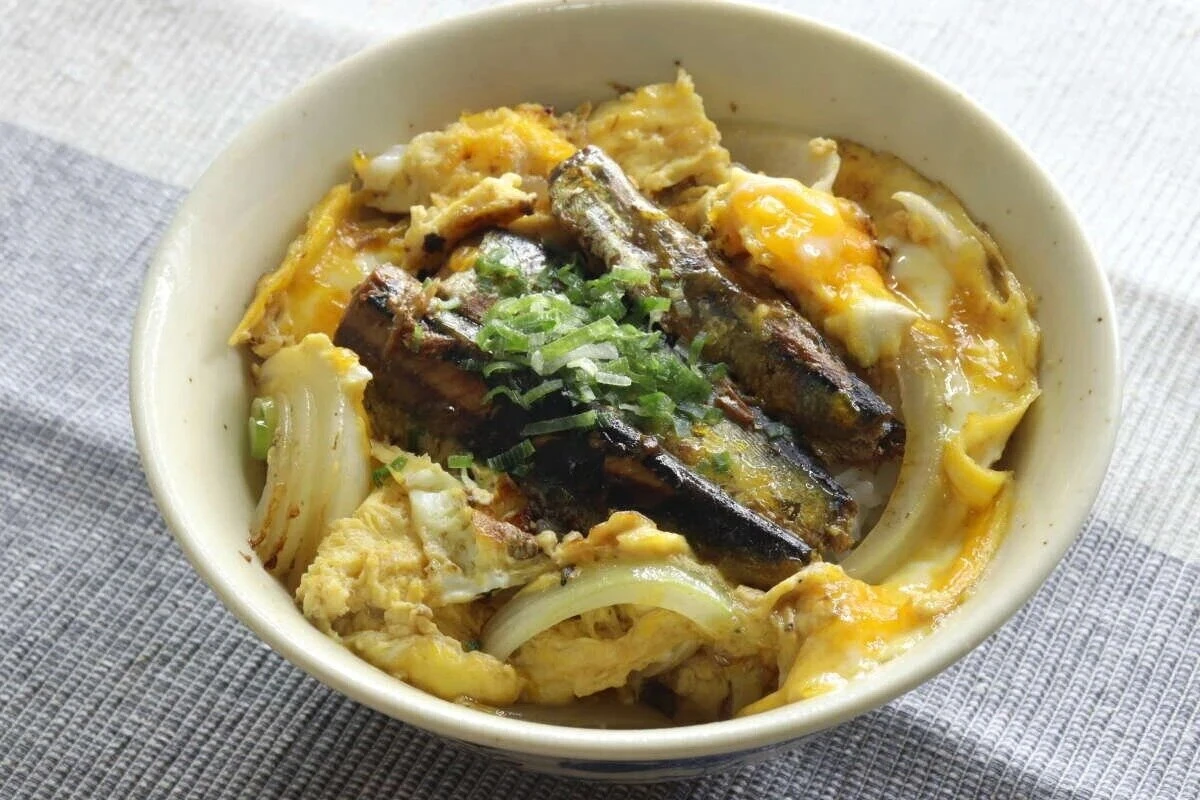 いわし醤油煮と卵、玉ねぎが乗った丼ぶりを上から撮影 いわし醤油煮と卵、玉ねぎが乗った丼ぶりを上から撮影