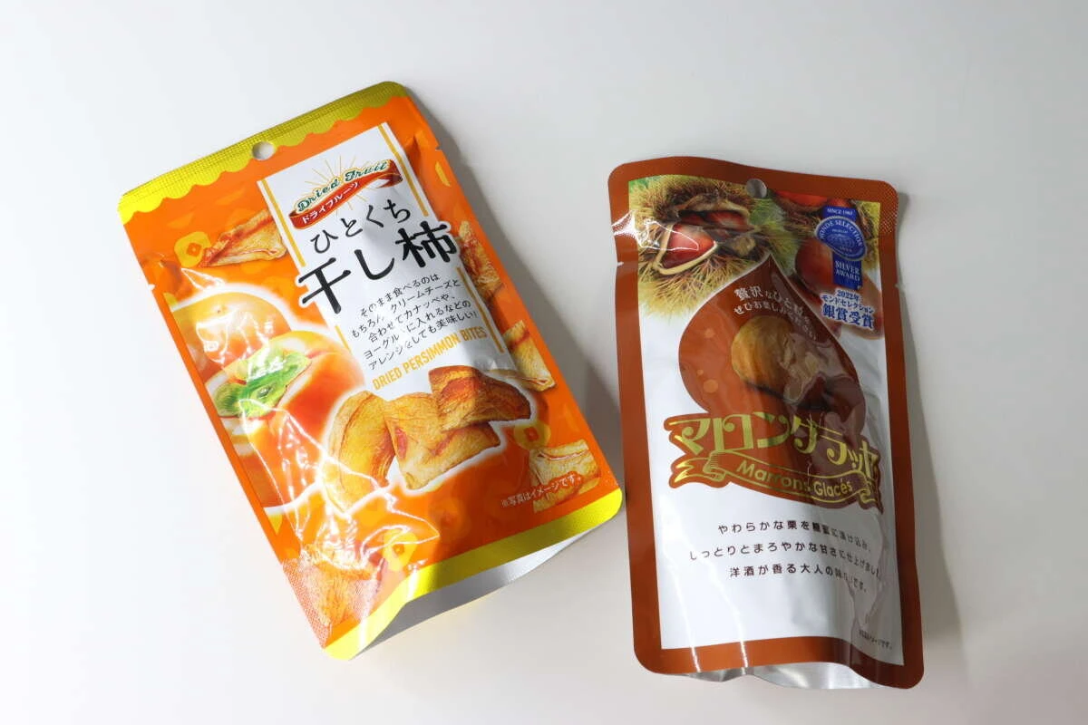 オレンジ色の「ひとくち干し柿」と茶色の「マロングラッセ」のパッケージが並べられている