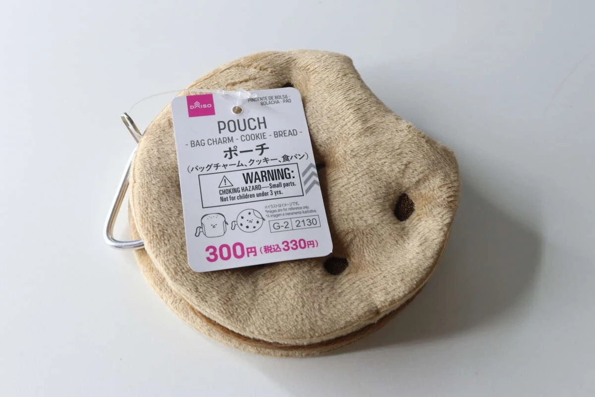 商品タグが付いたクッキー型の茶色いボアポーチが白背景に置かれている 商品タグが付いたクッキー型の茶色いボアポーチが白背景に置かれている