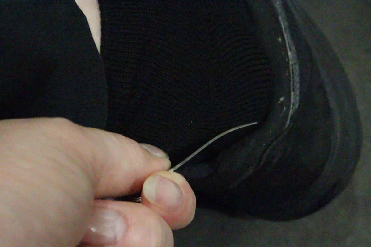 黒い靴を履く際に、手でミニ靴ベラをかかとに当てて使用している様子 黒い靴を履く際に、手でミニ靴ベラをかかとに当てて使用している様子