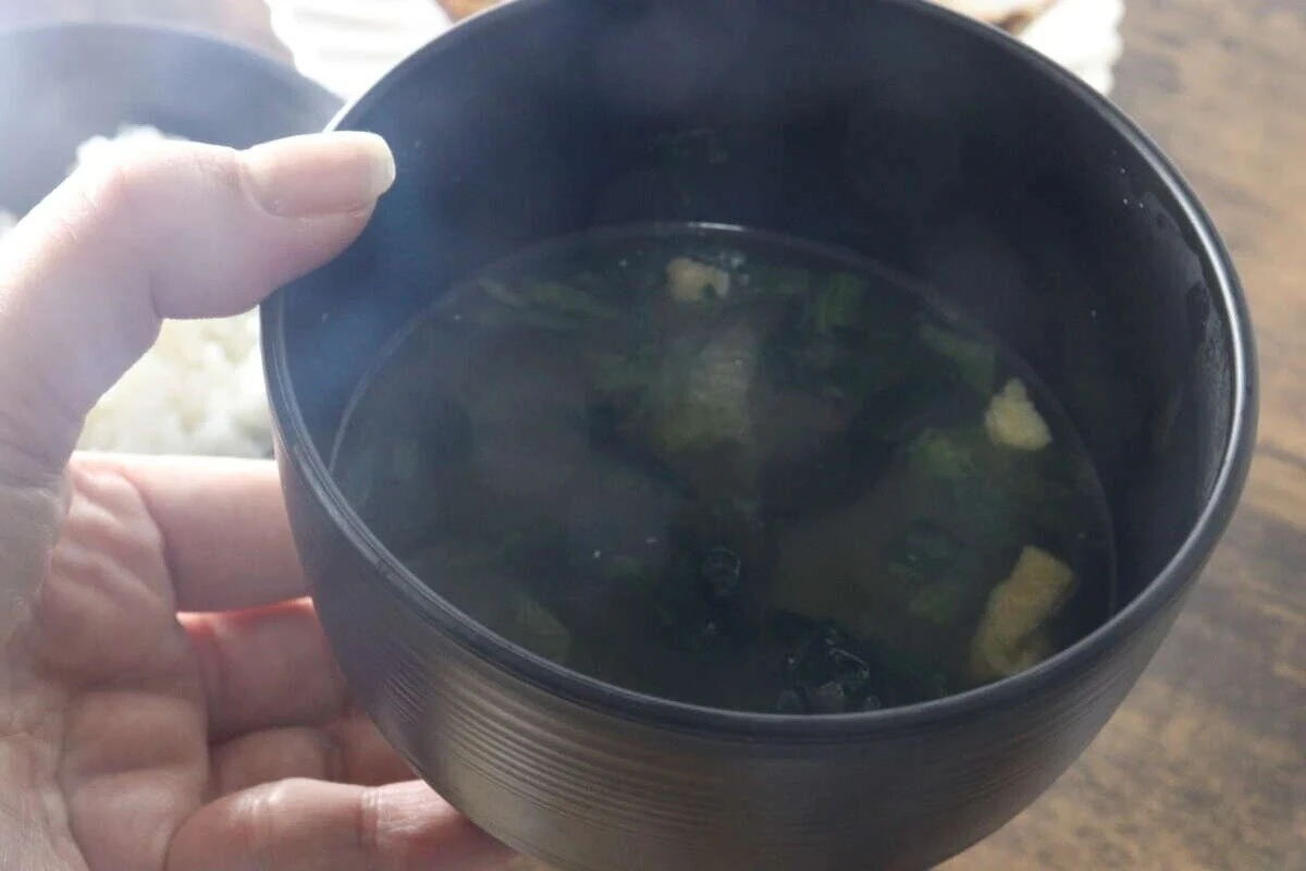 ダイソーの汁椀に盛られた味噌汁を手に持つ様子