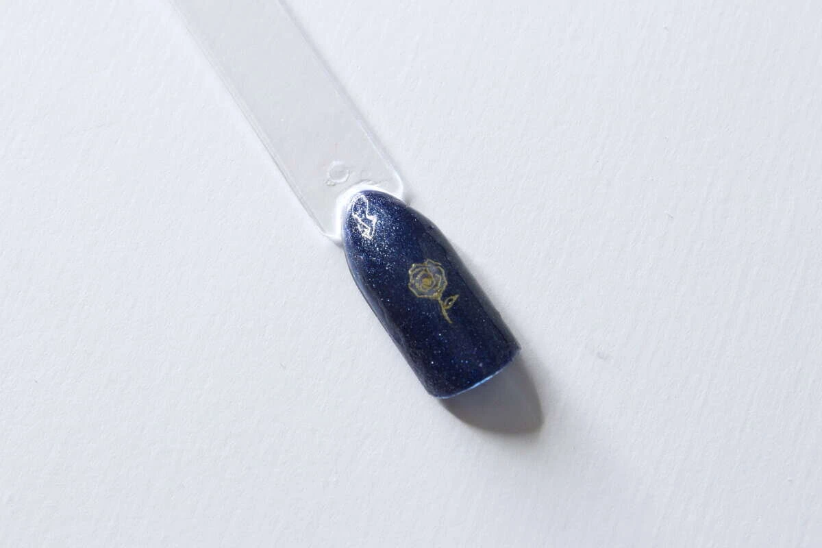 トップコートを塗り終えてきれいに仕上がった薔薇デザインのネイルチップ