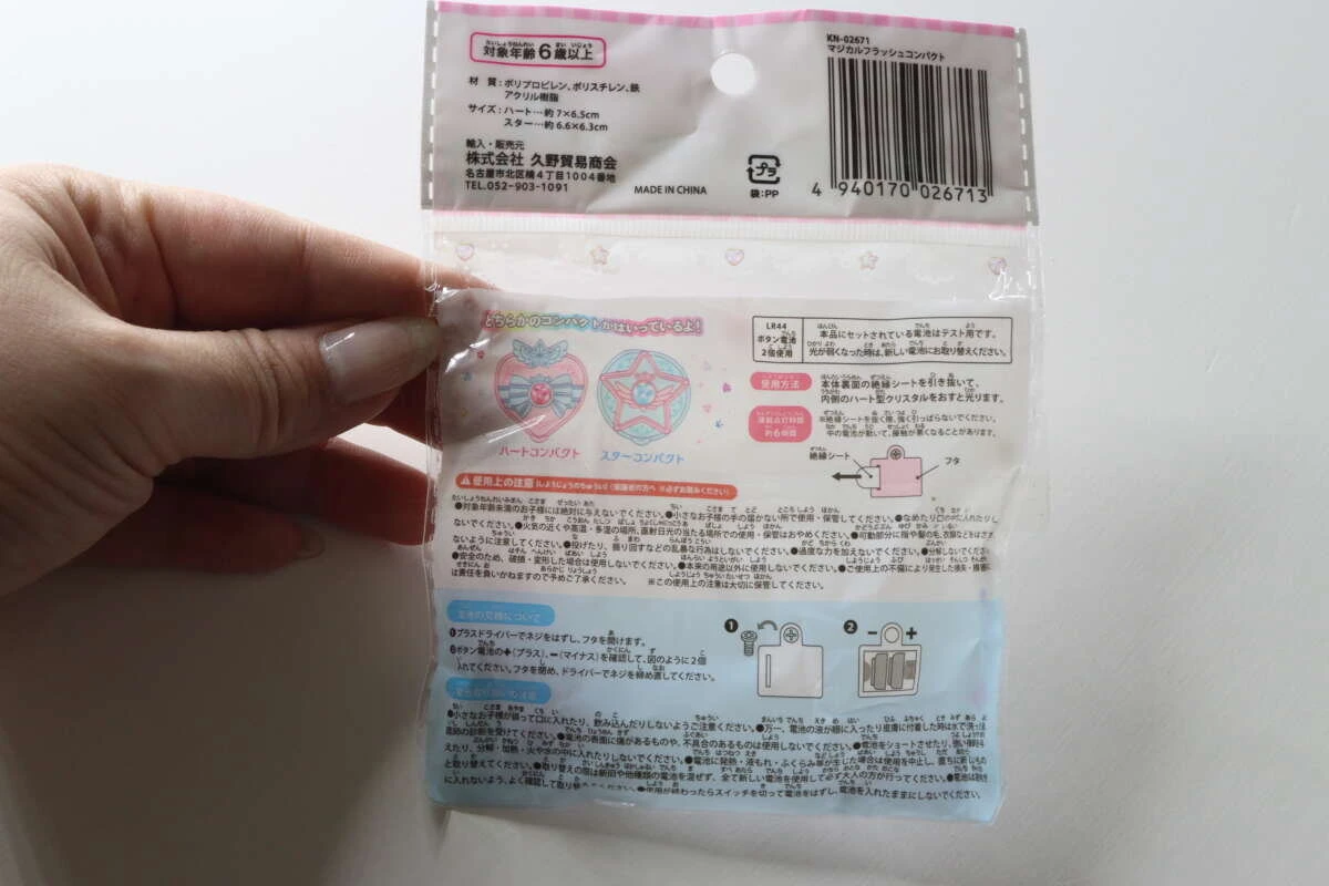 女性の手が持っているマジカルフラッシュコンパクトのパッケージ裏面。注意書きや説明が記載されている