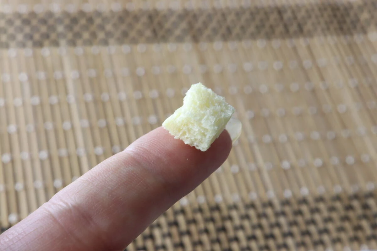 人差し指の先に、四角いクルトンが1粒乗っている 人差し指の先に、四角いクルトンが1粒乗っている