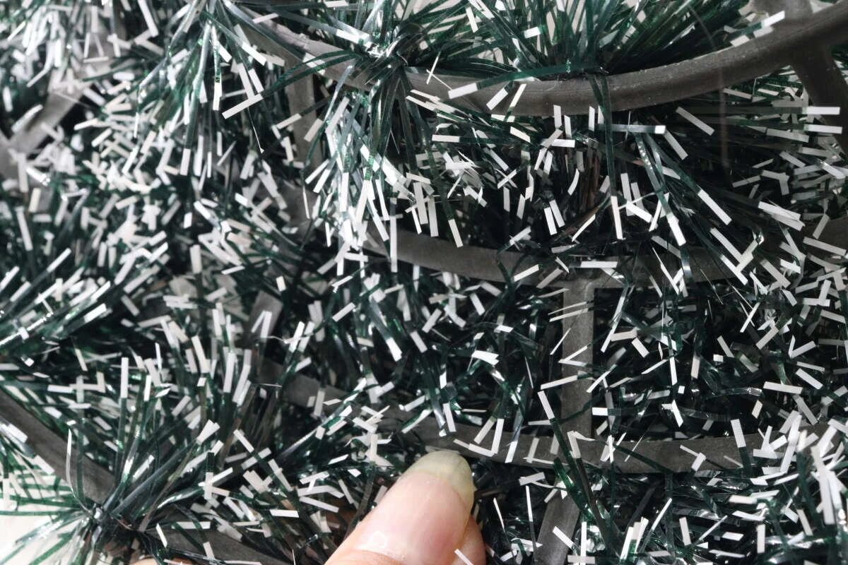 クリスマスリースのモールのアップ。指でモールの骨組み部分を触り、作りを確認している。 クリスマスリースのモールのアップ。指でモールの骨組み部分を触り、作りを確認している。