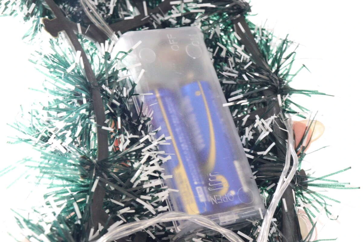 クリスマスリースに隠された電池ボックス。単三電池が2本入っているのが透けて見える。 クリスマスリースに隠された電池ボックス。単三電池が2本入っているのが透けて見える。