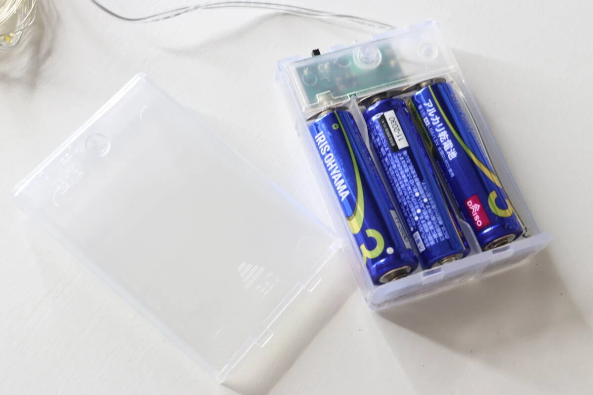 ストリングライトの電池ボックスに単3形乾電池3本を入れている様子。 ストリングライトの電池ボックスに単3形乾電池3本を入れている様子。