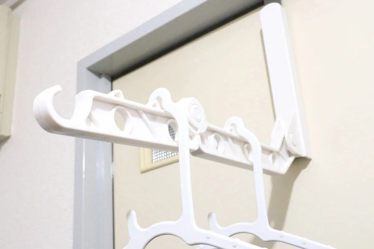 展開した白い物干しラックにハンガーが掛けられている使用中の様子 展開した白い物干しラックにハンガーが掛けられている使用中の様子