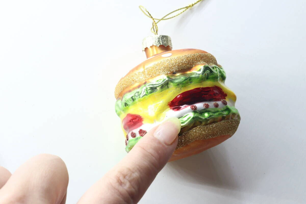 指でハンバーガーオーナメントのリアルなレタス部分を指し示している様子