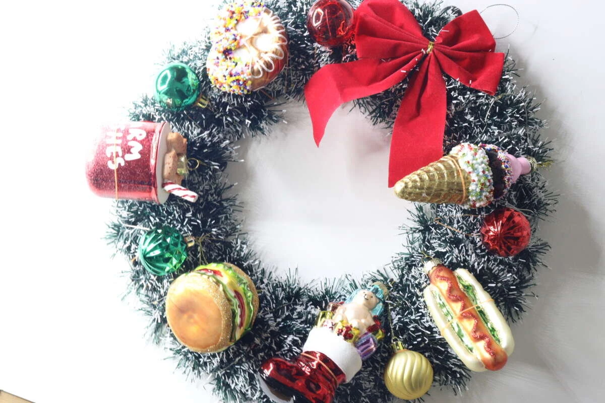 緑色のモールのクリスマスリースにハンバーガーやホットドッグなどのオーナメントが飾られている様子