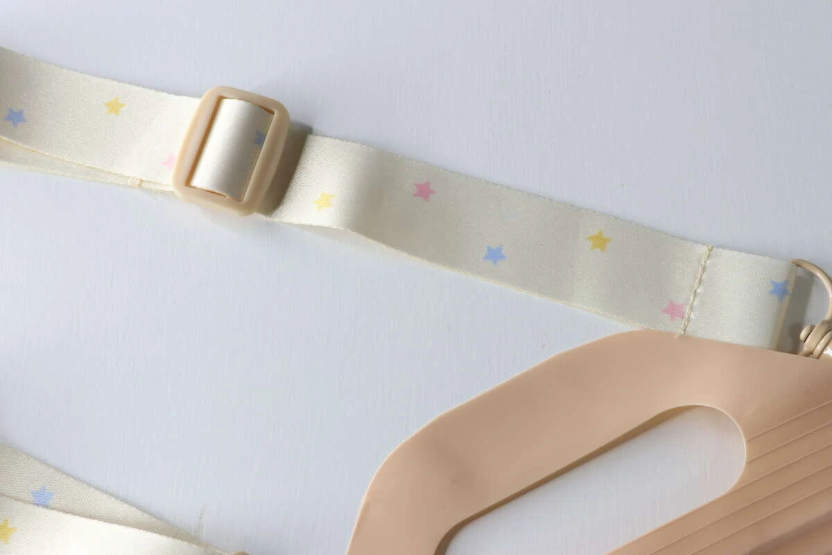 星模様が散りばめられた淡い色のストラップと長さ調節パーツの接写 星模様が散りばめられた淡い色のストラップと長さ調節パーツの接写