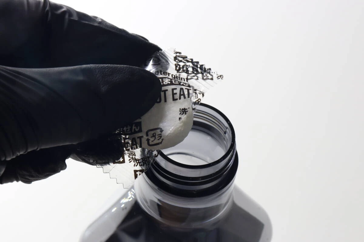 黒い手袋をした手で錠剤をスプレーボトルに入れている瞬間