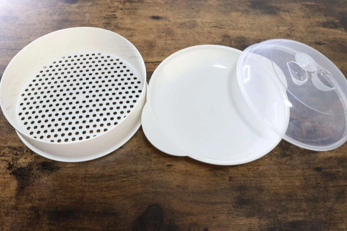 白いざるプレートと受け皿、透明なドーム型のフタが並んだ蒸し器 白いざるプレートと受け皿、透明なドーム型のフタが並んだ蒸し器