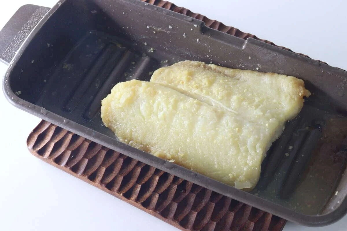 マルチトレーの波型底面に焼かれた魚の切り身が乗っている状態 マルチトレーの波型底面に焼かれた魚の切り身が乗っている状態