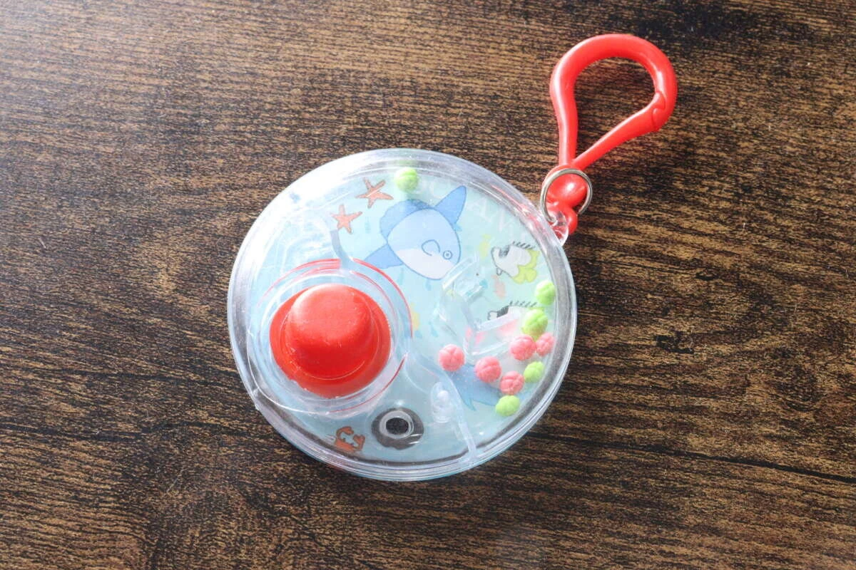 透明な本体に赤いボタンとキーホルダーがついた全体像 透明な本体に赤いボタンとキーホルダーがついた全体像