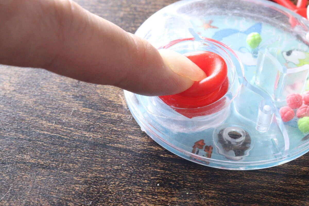 赤いボタンを指で押して水流を起こしている様子 赤いボタンを指で押して水流を起こしている様子