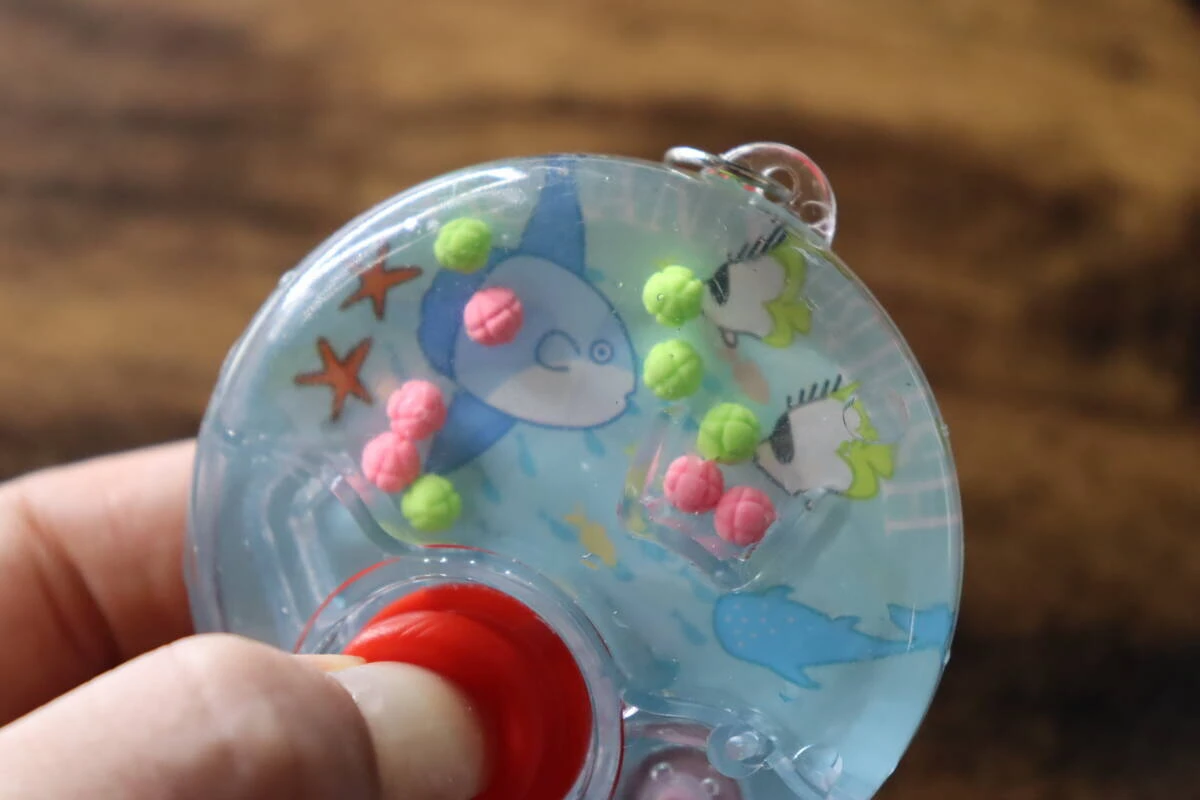 中に水とカラフルなボールが入ったゲーム機を操作する様子 中に水とカラフルなボールが入ったゲーム機を操作する様子