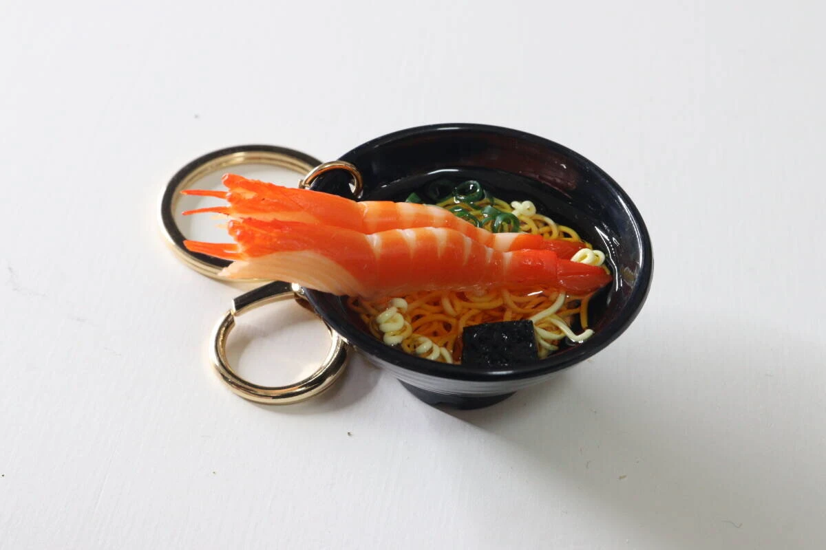 黒いお椀に入った巨大なえび付きうどんキーホルダーの斜め上からの写真