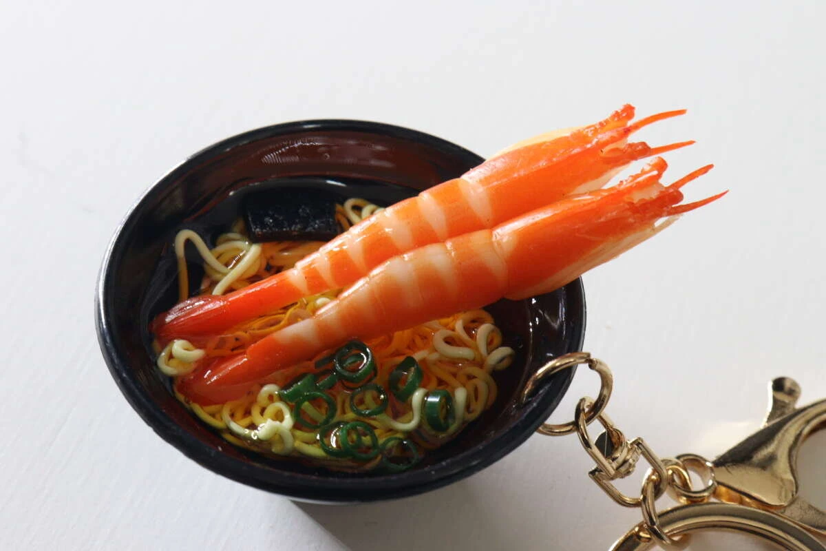 器から豪快にはみ出す2尾の大きなえびがリアルなうどんキーホルダーの接写