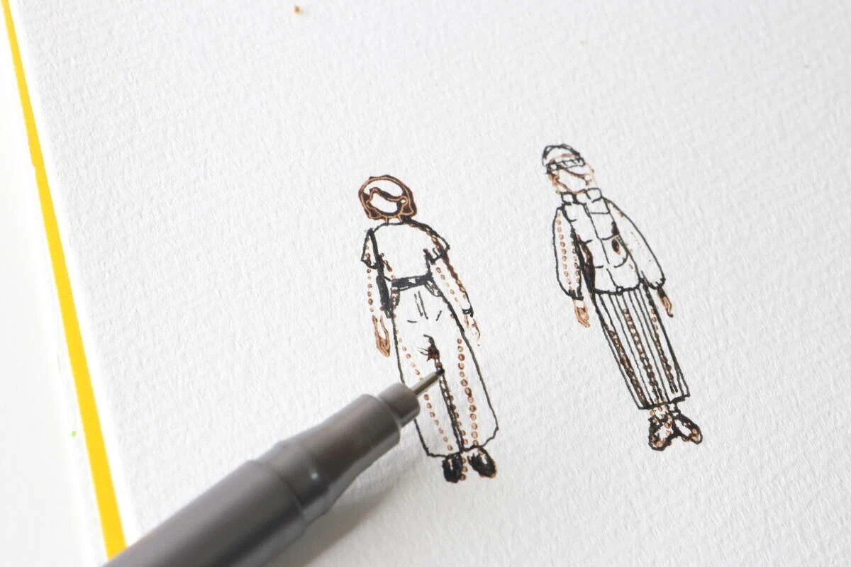 押したスタンプの上からペンで服のイラストを書き込んでいる様子 押したスタンプの上からペンで服のイラストを書き込んでいる様子