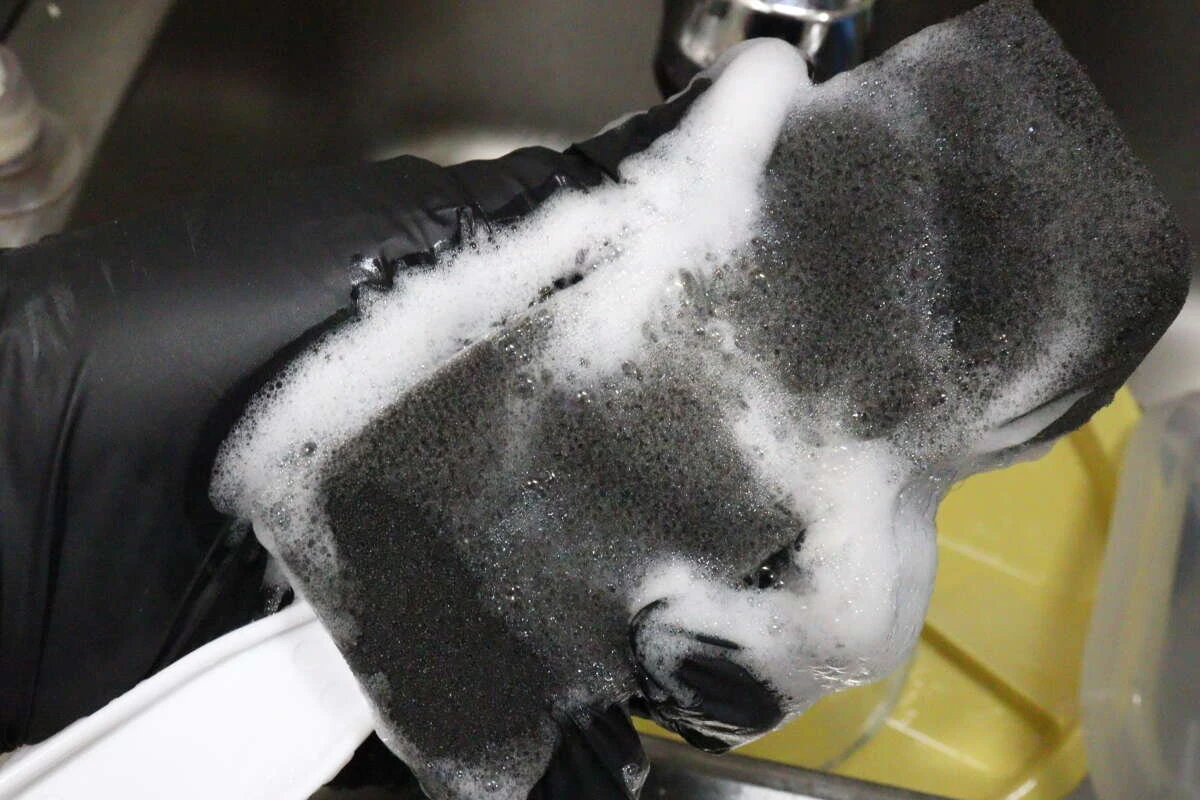 黒いスポンジに洗剤を含ませてしっかりと泡立てているところ 黒いスポンジに洗剤を含ませてしっかりと泡立てているところ