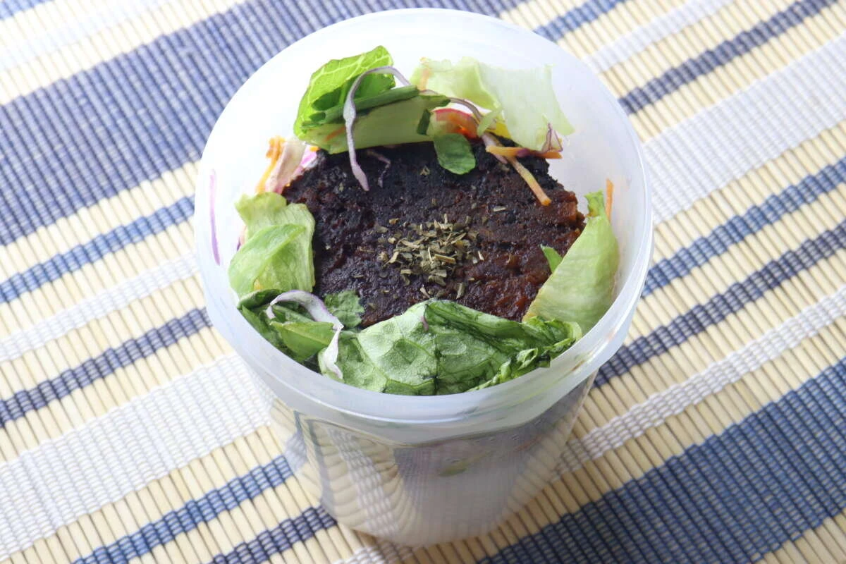 ご飯やハンバーグ、レタスをロコモコ丼風に詰め込んだカップ型ランチボックスの上からの撮影 ご飯やハンバーグ、レタスをロコモコ丼風に詰め込んだカップ型ランチボックスの上からの撮影