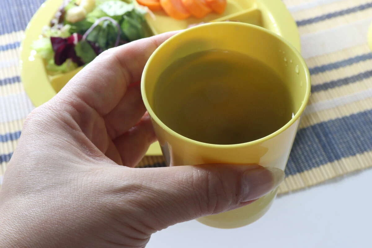 黄色いカップを持って飲み物を飲もうとしているシーン 黄色いカップを持って飲み物を飲もうとしているシーン