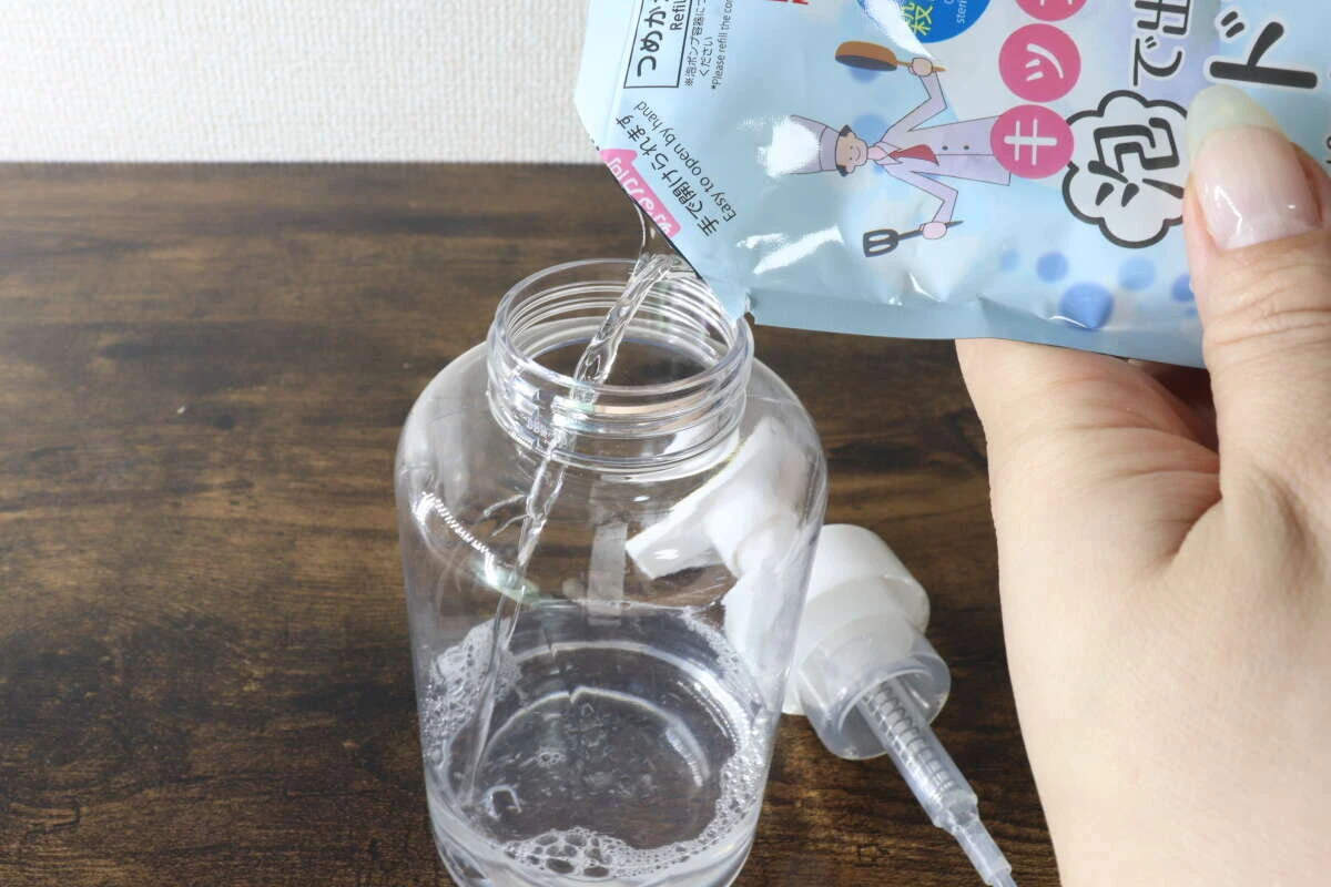 透明な専用ポンプボトルにハンドソープを詰め替えている様子