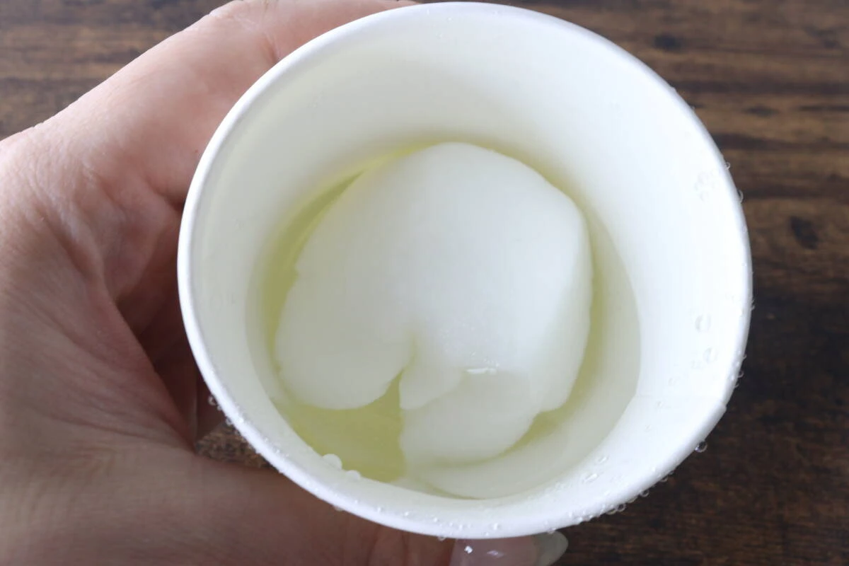 紙コップの水に浸された圧縮タオルが数秒で大きく膨らんでいる様子 紙コップの水に浸された圧縮タオルが数秒で大きく膨らんでいる様子