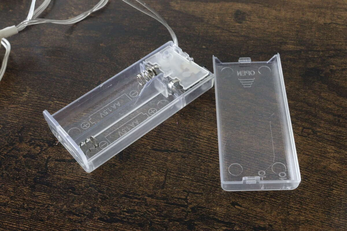スライド式のフタを開けた透明な乾電池ボックスの内部構造