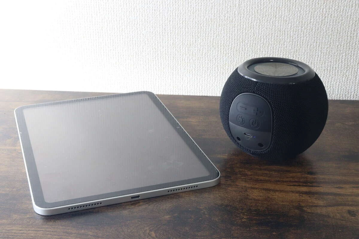タブレット端末と黒いボール形スピーカーを並べて置いている様子