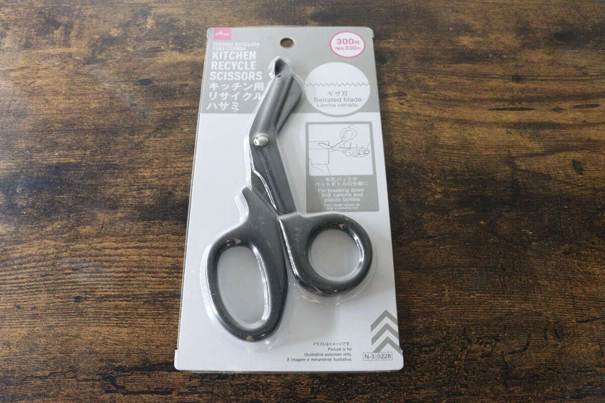 木製テーブルの上に置かれたパッケージ入りのキッチン用リサイクルハサミ