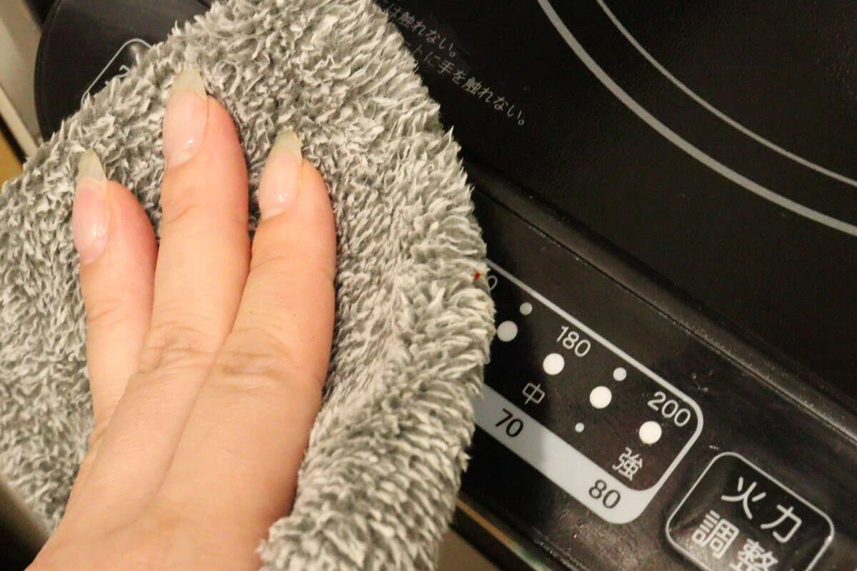 操作パネル部分にふきんをあてて丁寧に拭き掃除をしている様子