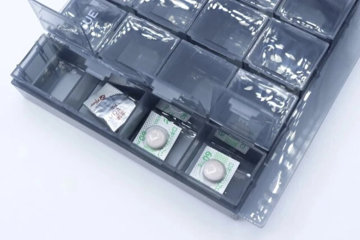 グレーの7DAYSピルケースに、個包装の薬が数錠ずつ入っている様子 グレーの7DAYSピルケースに、個包装の薬が数錠ずつ入っている様子