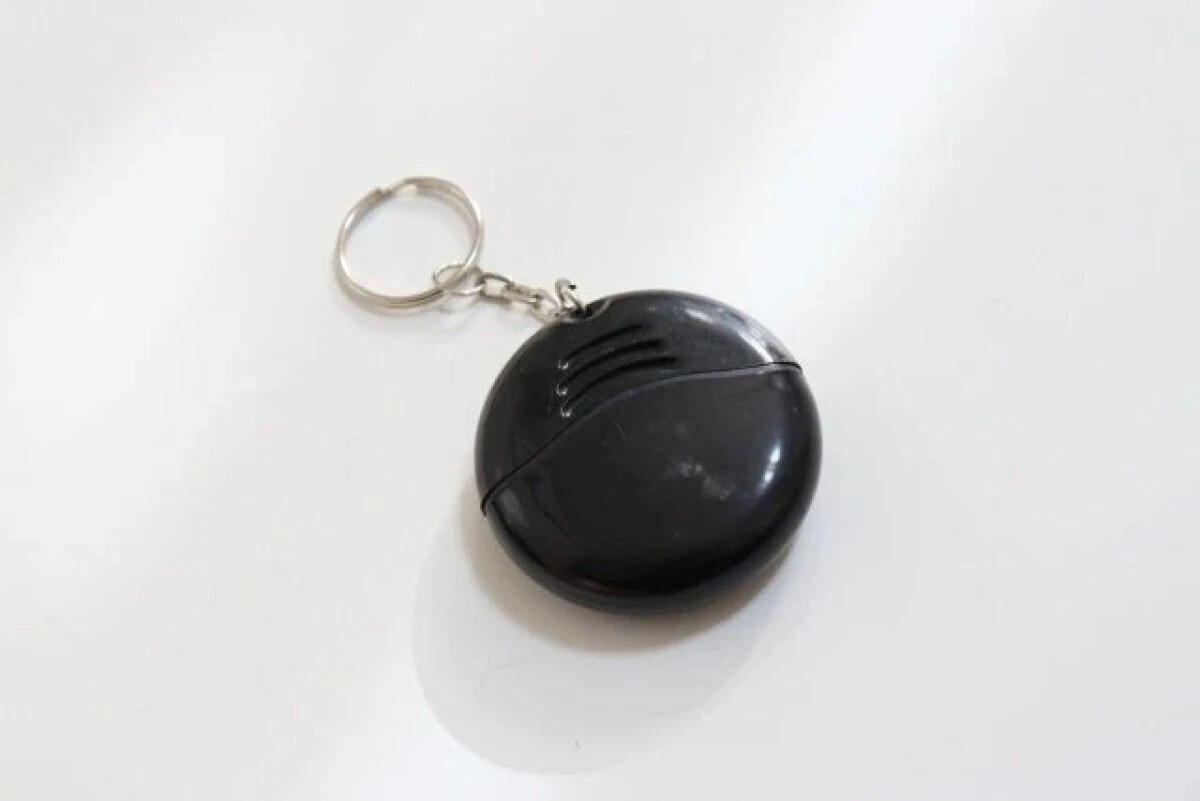 白い背景に置かれた黒い円盤状のキーホルダー型ドライバー 白い背景に置かれた黒い円盤状のキーホルダー型ドライバー