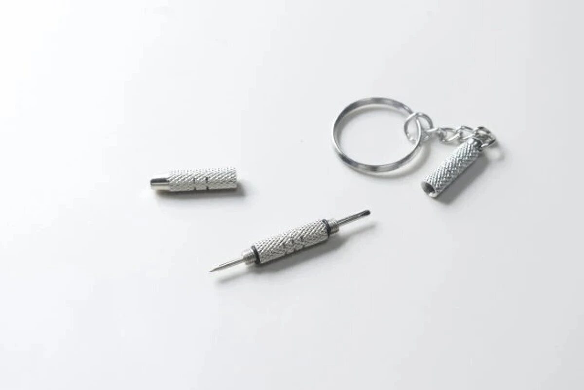 分解された銀色のメガネ専用ドライバーの部品が並べられている 分解された銀色のメガネ専用ドライバーの部品が並べられている