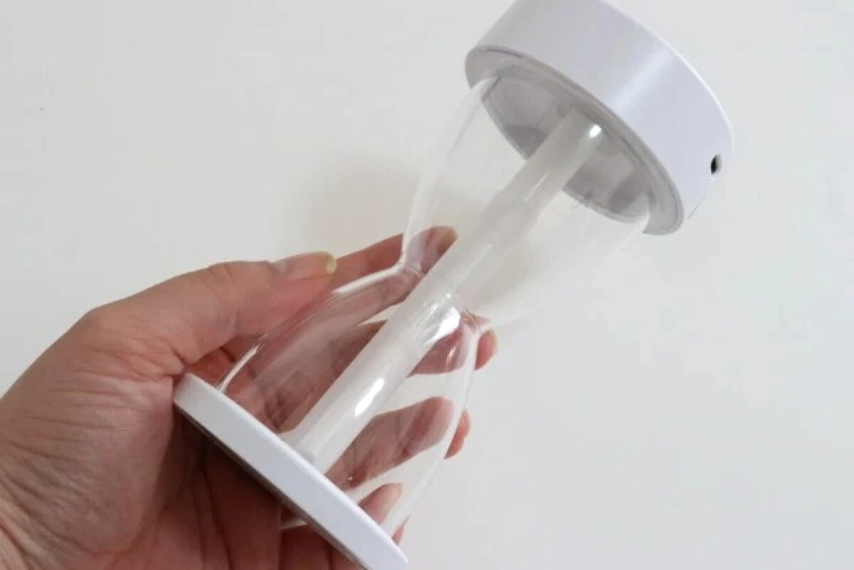 手に持って砂時計型デザインを確認している加湿器の全体像