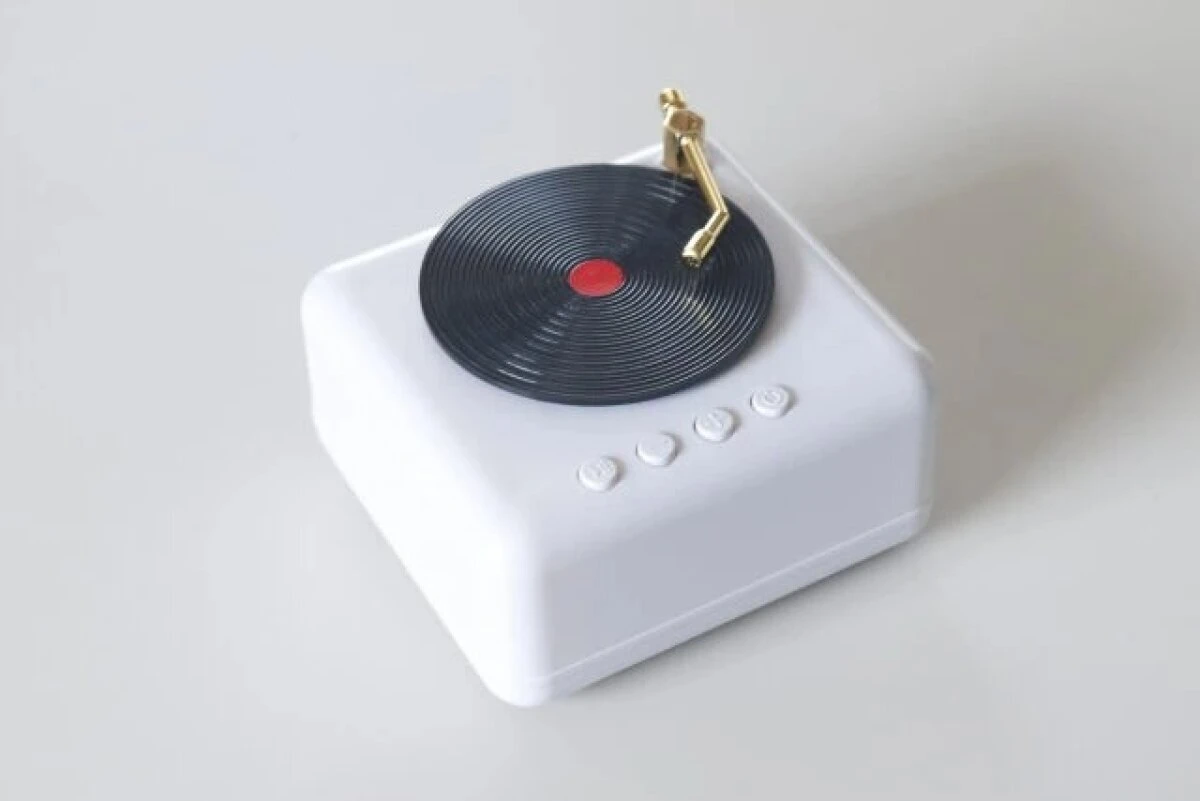 白いテーブルの上に置かれたレコードプレーヤー型の白いレトロスピーカー 白いテーブルの上に置かれたレコードプレーヤー型の白いレトロスピーカー