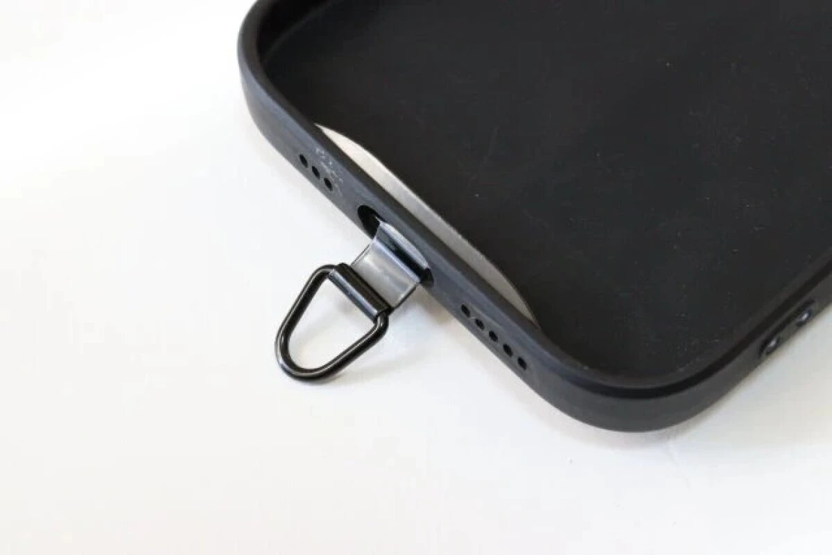 スマートフォンケースの下部からストラップホルダーのフックを出している様子 スマートフォンケースの下部からストラップホルダーのフックを出している様子