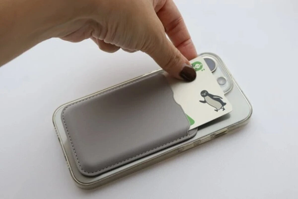 スマホの背面に装着したカードホルダーからカードを出し入れしている手元 スマホの背面に装着したカードホルダーからカードを出し入れしている手元