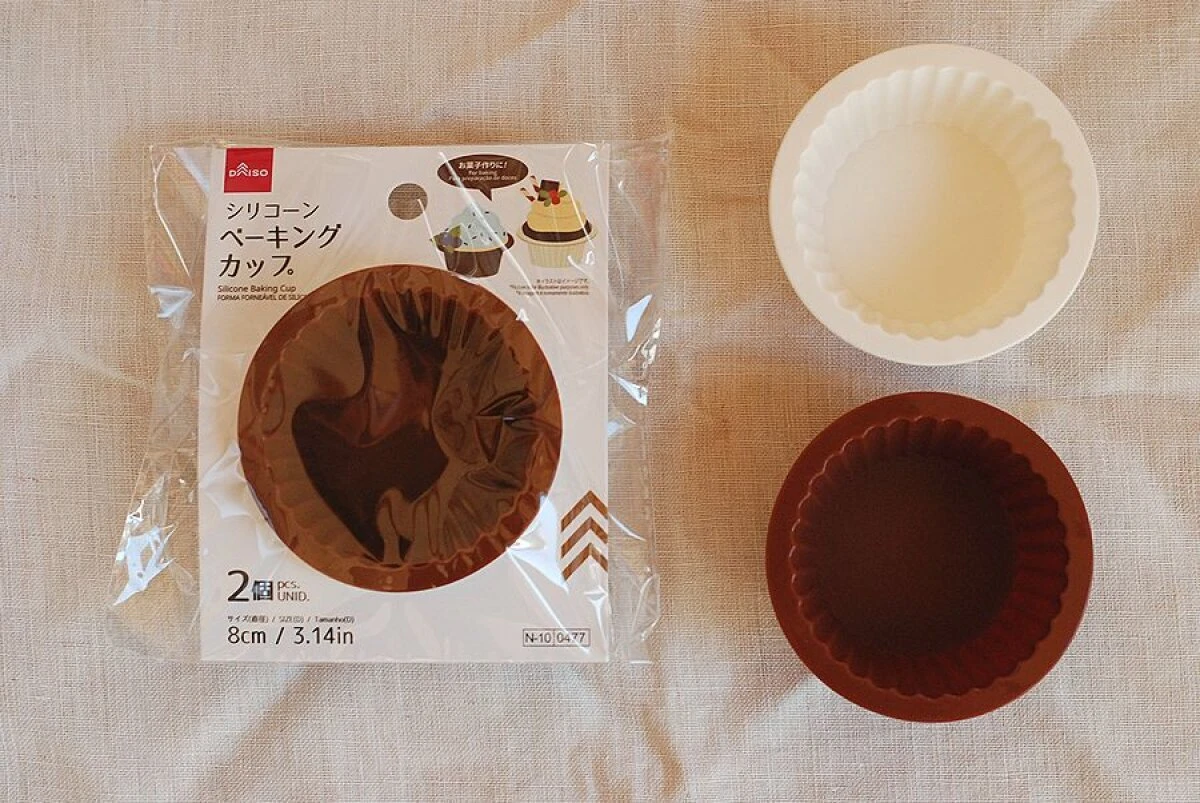 ダイソーのシリコーンベーキングカップのパッケージと白と茶色のカップが並べられた様子 ダイソーのシリコーンベーキングカップのパッケージと白と茶色のカップが並べられた様子
