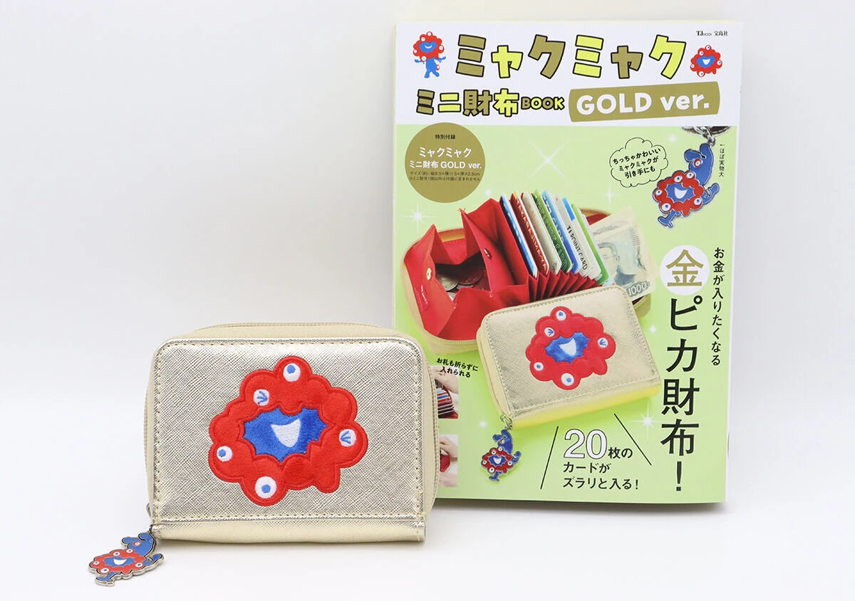 ゴールドのミャクミャクミニ財布と、付録付きムック本「ミャクミャク ミニ財布BOOK GOLD ver.」が並べられている ゴールドのミャクミャクミニ財布と、付録付きムック本「ミャクミャク ミニ財布BOOK GOLD ver.」が並べられている
