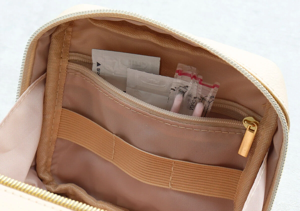 ポーチの内側にあるファスナーポケットに絆創膏やサンプル品が収納されている様子 ポーチの内側にあるファスナーポケットに絆創膏やサンプル品が収納されている様子