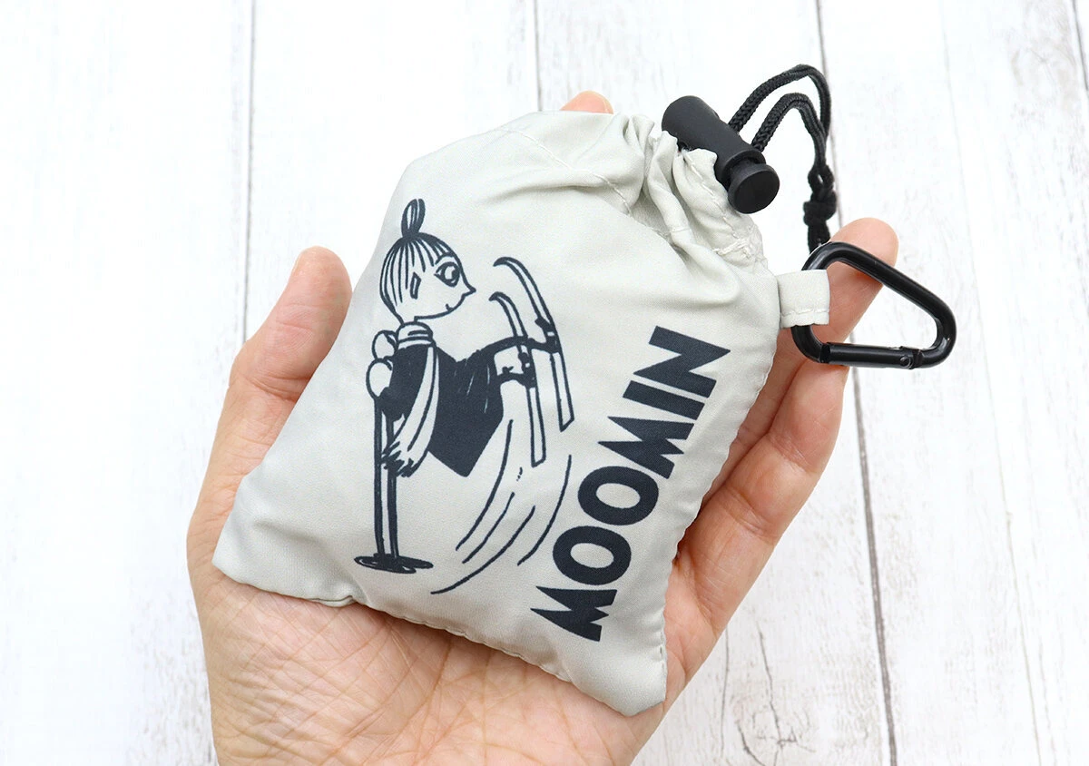 手のひらに、リトルミイのイラストと「MOOMIN」の文字が入った、小さく収納されたエコバッグが乗せられている。 手のひらに、リトルミイのイラストと「MOOMIN」の文字が入った、小さく収納されたエコバッグが乗せられている。