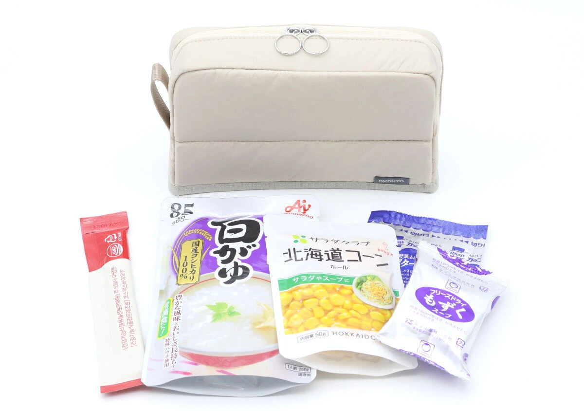 ベージュのポーチの前に、ポーチに収納されていたレトルト食品やフリーズドライ食品が並べられている ベージュのポーチの前に、ポーチに収納されていたレトルト食品やフリーズドライ食品が並べられている