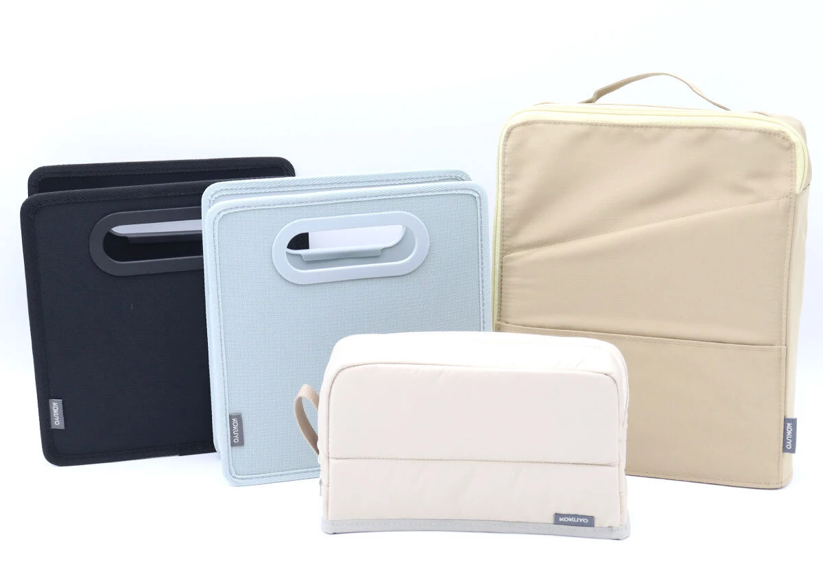 コクヨの収納用品シリーズ。黒、水色、ベージュのポーチやファイルが複数並べられている コクヨの収納用品シリーズ。黒、水色、ベージュのポーチやファイルが複数並べられている