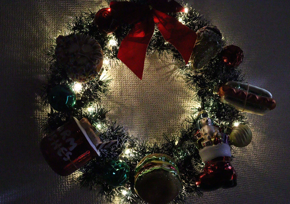 クリスマスリースにオーナメントとライトをつけて飾っている様子 クリスマスリースにオーナメントとライトをつけて飾っている様子