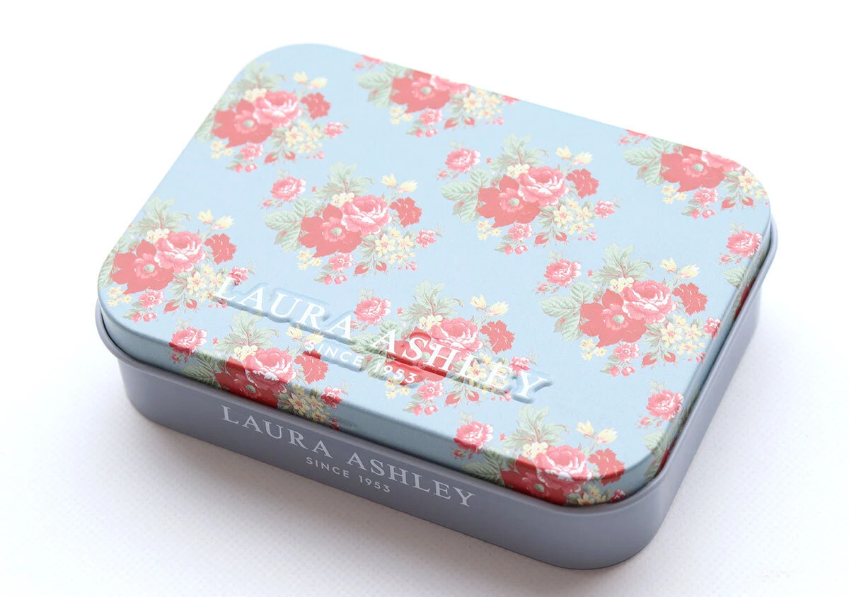 華やかなローズ柄が描かれ立体的なロゴが入ったブルーの缶ケース