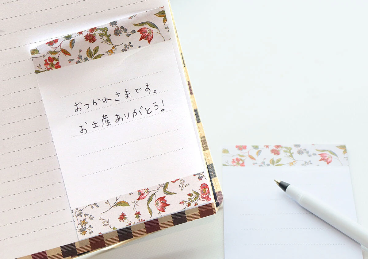 手帳に貼り付けられた小花柄のメモ付箋と手書きのメッセージ